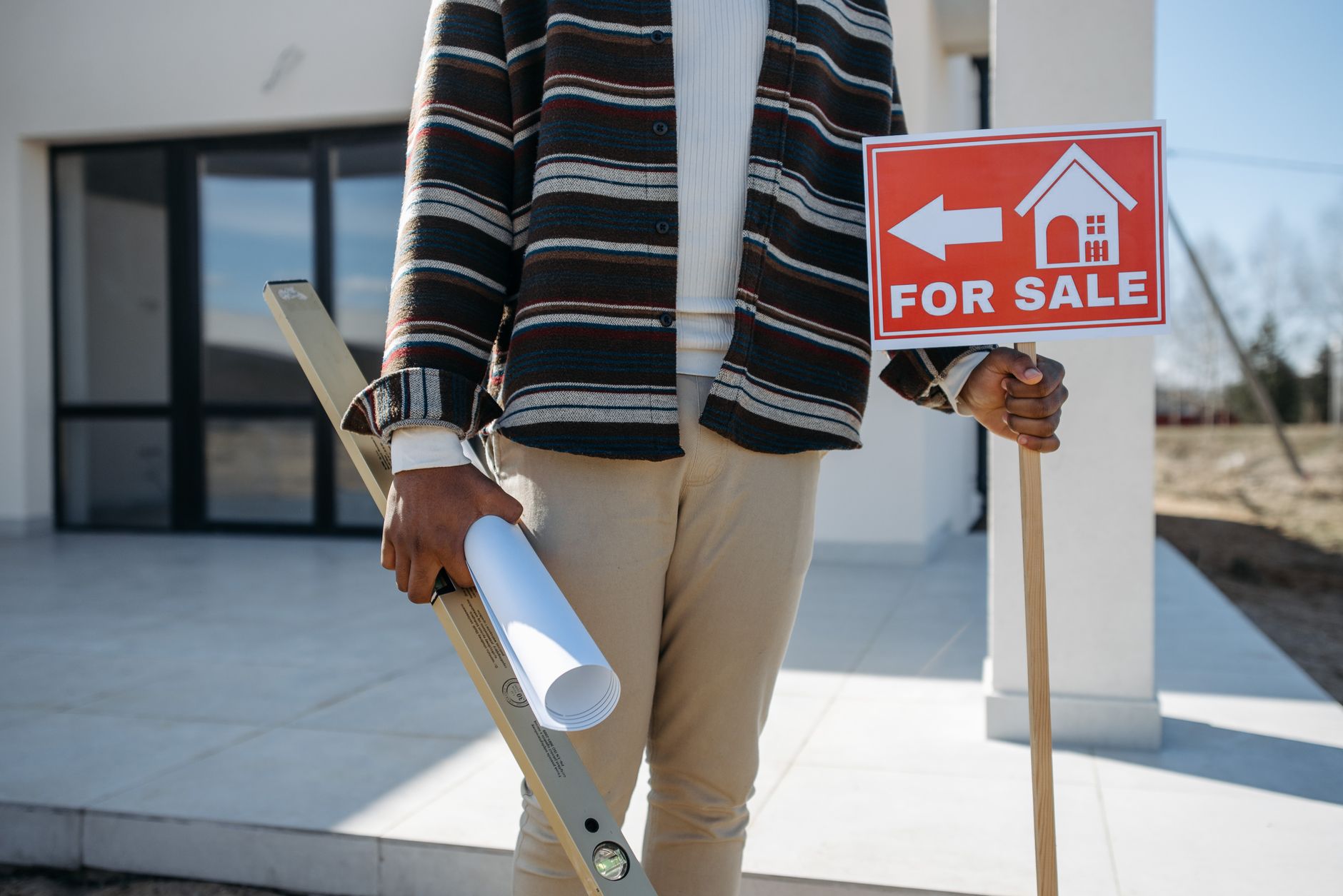 Agent immobilier avec pancarte à vendre et plan